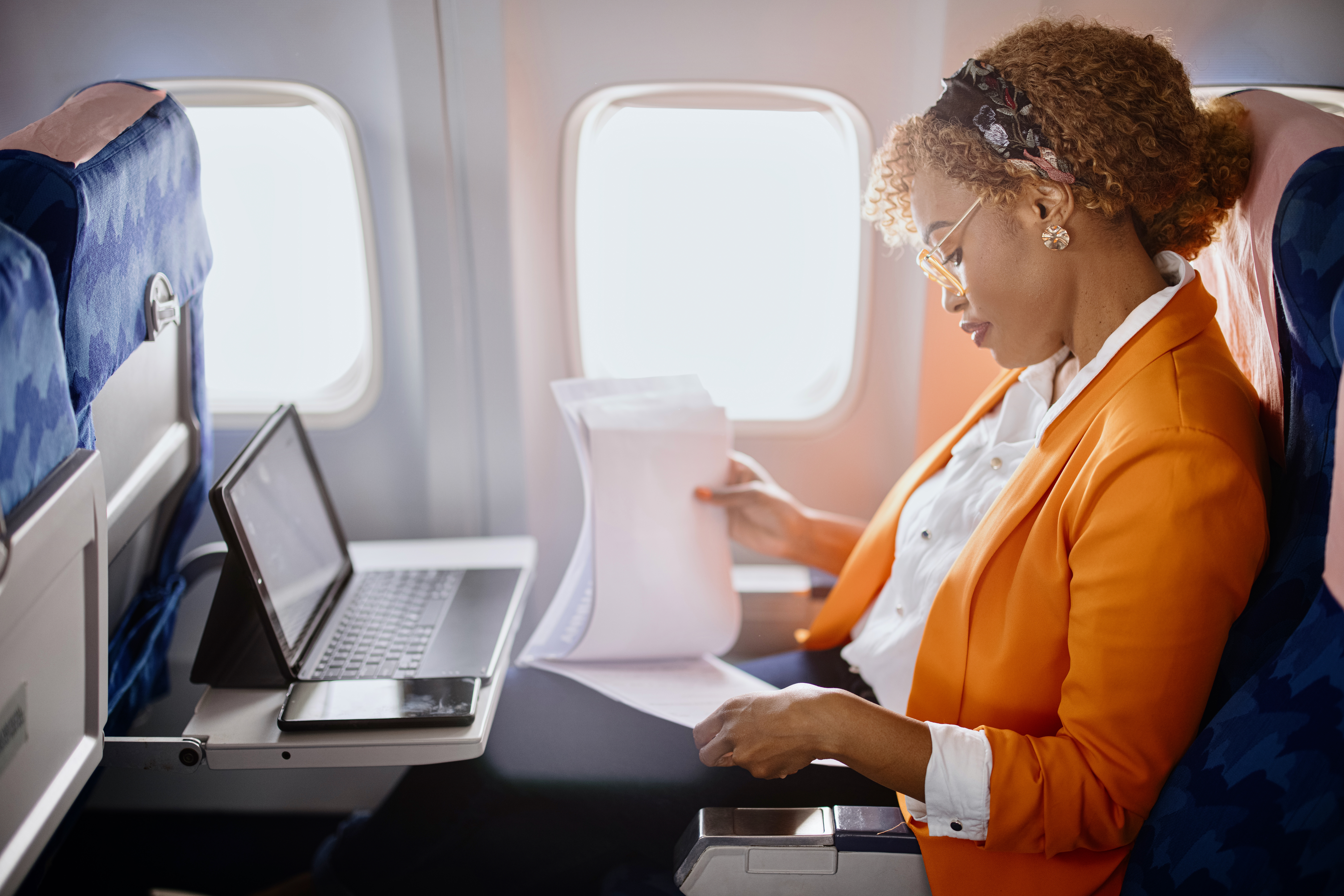 woman in business attire on plane working