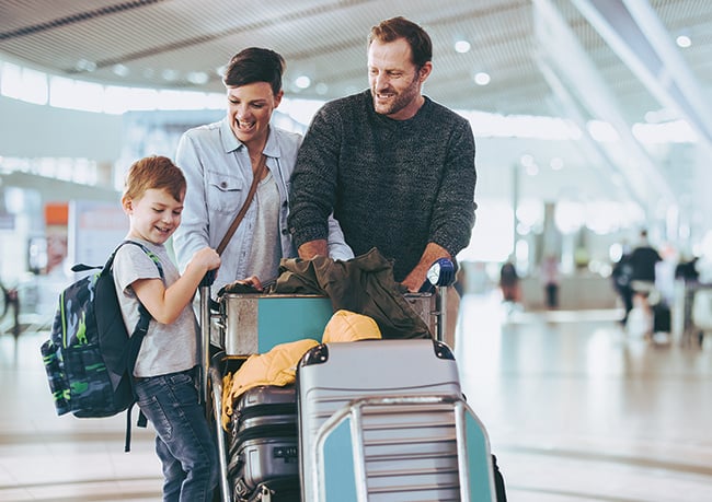 family walking through airport to vacation